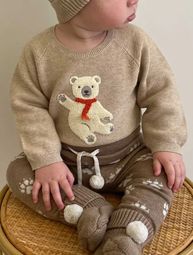 Baby in sweater with bear toy